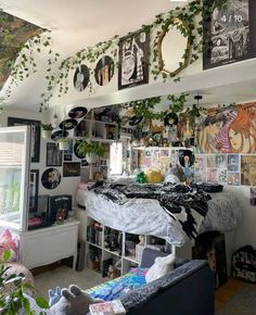 a room filled with lots of plants and pictures hanging on the wall next to a bed