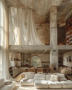 a living room filled with white furniture and lots of curtains hanging from the ceiling above