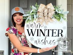 a woman holding up a sign that says warm winter wishes