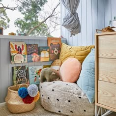 a room with bookshelves and stuffed animals in baskets on the floor next to it