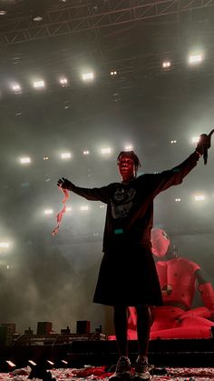 a man standing on top of a stage with his arms spread out in front of him