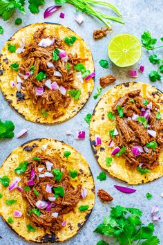 three pulled pork tacos with cilantro and lime