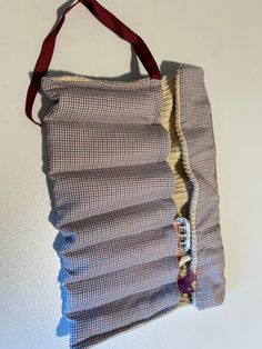 a handbag hanging on the wall with some fabric attached to it's side