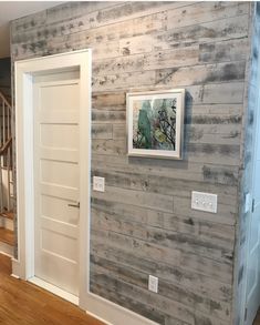 an empty room with wood paneling on the walls and wooden stairs leading up to it