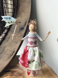 a small wooden doll is standing on a piece of wood with a sign that says magic man