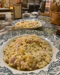 two plates filled with macaroni and cheese on top of a table next to each other