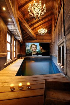 a room with a pool and chandelier hanging from the ceiling is shown in an instagram