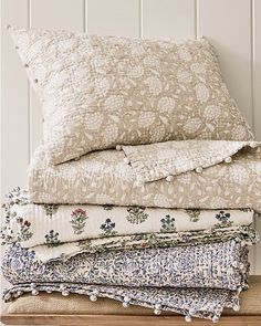 a stack of pillows sitting on top of a wooden table