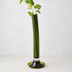 a green vase with some flowers in it