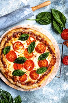 a pizza sitting on top of a pan covered in cheese and toppings next to a knife