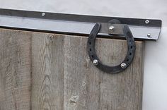 a close up of a wooden door with a metal handle and ring on the side