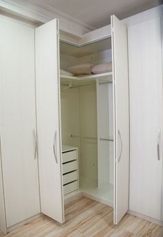 an empty closet with two white doors and drawers on the bottom shelf is seen in this image