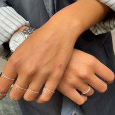 two people with matching rings on their hands, one holding the other's hand