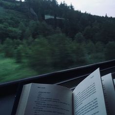 an open book sitting on top of a train window