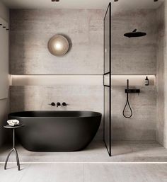 a black bath tub sitting in a bathroom next to a shower