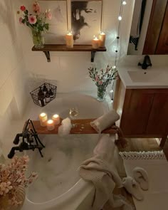 a bathroom with candles and flowers in the bathtub