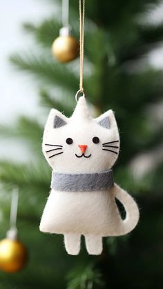 a white cat ornament hanging from a christmas tree