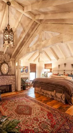 a large bed sitting under a chandelier in a bedroom next to a fireplace