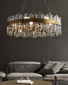 a modern chandelier hanging from the ceiling in a living room