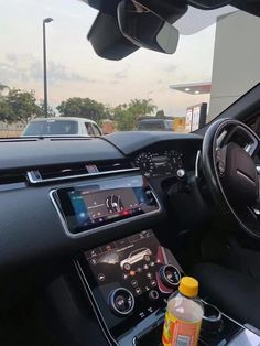 the interior of a car with an electronic display and steering wheel controls, dashboard lights, dash camera, and other items