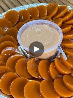 a platter filled with sliced oranges and dipping sauce