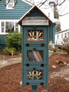 a blue birdhouse with many books in it