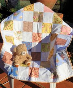 a teddy bear sitting in a patchwork chair