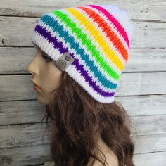 a woman wearing a multicolored knitted beanie hat on top of a mannequin head