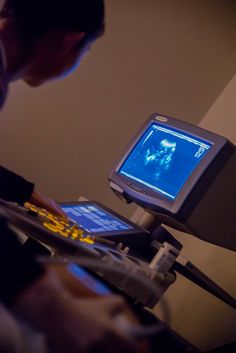 a man is looking at something on his computer screen while he looks at the monitor