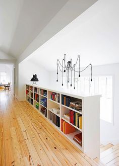 an empty room with bookshelves and chandelier hanging from the ceiling in it