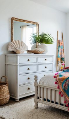 a bedroom with white furniture and a large mirror on top of the dresser next to it