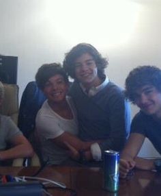 four young men sitting around a wooden table