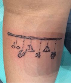 a black and white photo of a tattoo on the leg with different things hanging from it