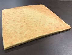 a piece of bread that is on top of a table with a black surface in front of it