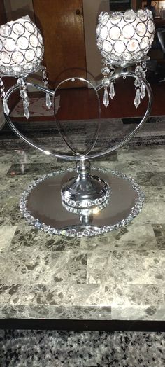 two crystal candle holders sitting on top of a marble table