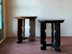 two wooden tables sitting next to each other on top of a tiled floor in front of a window