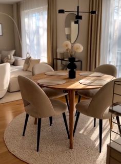 a dining room table with chairs and a rug on the floor in front of it