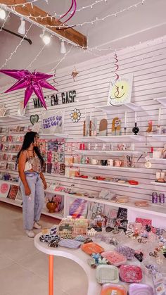 two women looking at items on display in a store with lights hanging from the ceiling