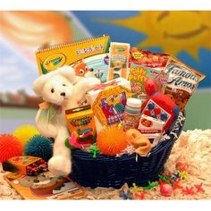 a teddy bear is sitting in a basket filled with toys and books, along with other items