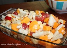 a glass dish filled with fruit on top of a wooden table