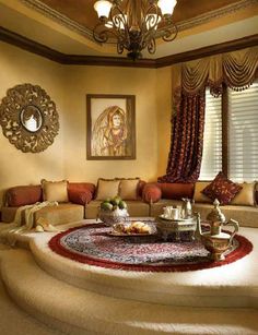 a living room filled with furniture and a chandelier hanging from the ceiling above it