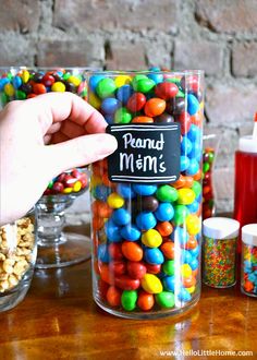 a person holding a jar filled with lots of colorful candies next to other candy