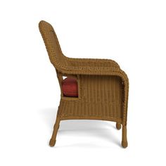 a brown wicker chair with a red pillow on it's seat cushion and back