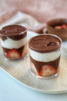 two desserts with strawberries and chocolate on a plate