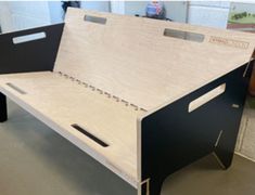 a wooden bed frame sitting on top of a floor next to a table with drawers