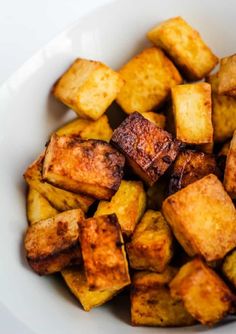 a white bowl filled with cooked cubed potatoes