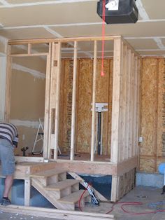 a man is working on the framing of a room in a new home under construction