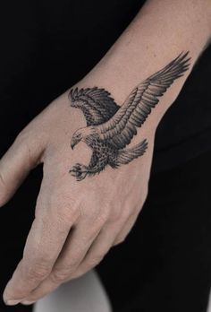 a woman's hand with a bird tattoo on it