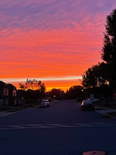 the sky is pink and orange as the sun goes down in an area with houses