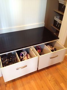 an open drawer with shoes in it sitting on a wooden floor next to a wall